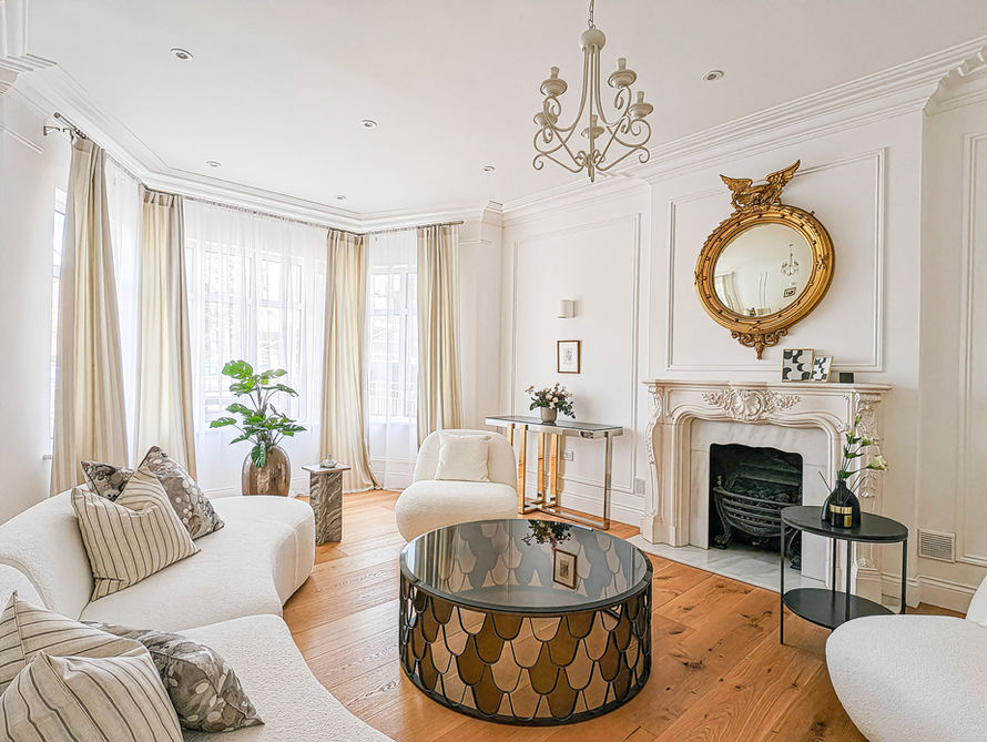 London home staging period formal reception room with fireplace, neutral sofa, and statement coffee table.