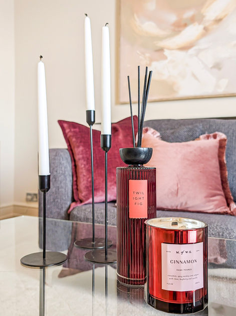 Styled coffee table vignette with reed diffuser and candle set against soft neutral walls, complementing a Victorian townhouse interior with contemporary accents.