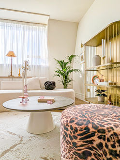 Close-up of sculptural boucle armchair and round coffee table styled in high-end home staging project