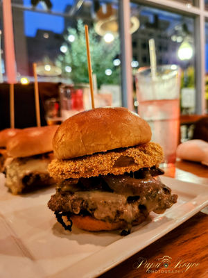 Closeup of a Cheeseburger with a fried green onion.