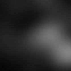 Photographie en plongée d'une femme allongée sereinement dans l'herbe haute, les yeux fermés et les cheveux étalés, exprimant un sentiment de liberté et de reconnexion à soi.