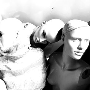 Plusieurs mannequins en noir et blanc, têtes serrées, dont un enveloppé de plastique bulle, dans un espace sombre pour illustrer les ouvrières invisibles et le texte Femmes, unissons-nous de Teresa Claramunt.