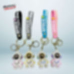 Cute astronaut-themed 3D keychain with colorful "Space" straps in black, gray, blue, and pink.