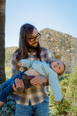 Father holds his young child among the stone structures and desert landscape at Mission Creek Preserve near Palm Springs.