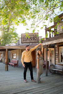 Pregnant couple dancing together on wooden boardwalk in Pioneertown maternity session near Joshua Tree