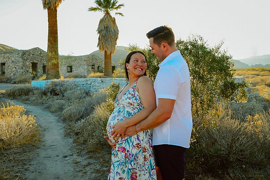 Palm Springs maternity photographer captures a joyful couple hugging and smiling during their desert session