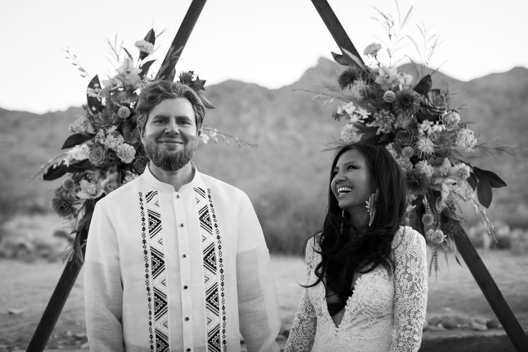 Bride and groom laughing during black and white portrait at Sacred Sands in Joshua Tree. Joshua Tree wedding photographer capturing candid desert moments.