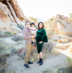 Maternity couple with their 3-year-old son, all smiling together by the rocks during Joshua Tree mini session.