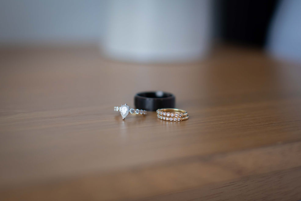 Wedding rings resting on a wooden nightstand at a Morada wedding Airbnb in Joshua Tree, captured in soft natural light before the ceremony.