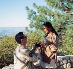 Man presenting an engagement ring while proposing on one knee during a surprise forest engagement in Idyllwild, California.