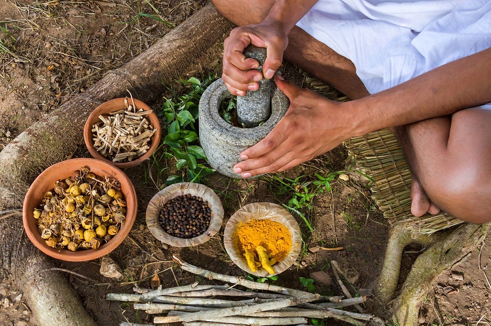 A man making Ayurvedic powders in a traditional way sitting on ground