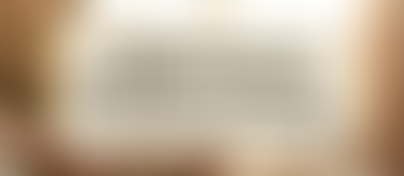 Woman in a soft setting sits by a window with flowers, holding a cup and notebook. Text: "3 Simple Ways to Embrace Your Feminine Energy Every Day.