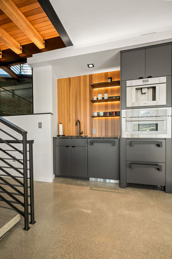 VOGO Cabinets modern black bar in a Denver home, with custom cabinetry and warm wood accent wall