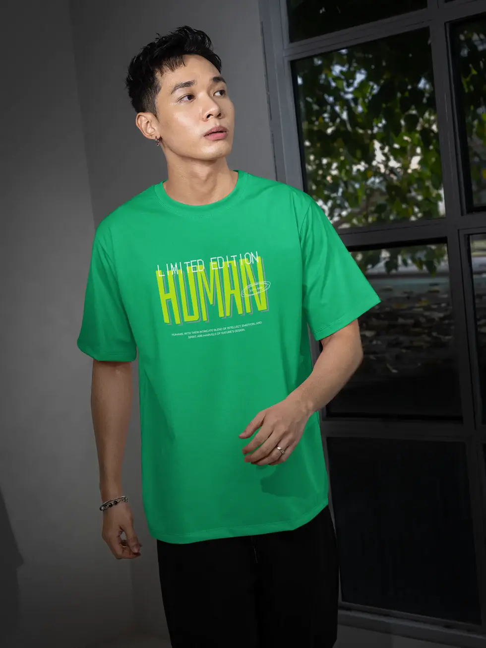 Model wearing neon green oversized t-shirt with “LIMITED EDITION HUMAN” graphic text on the front