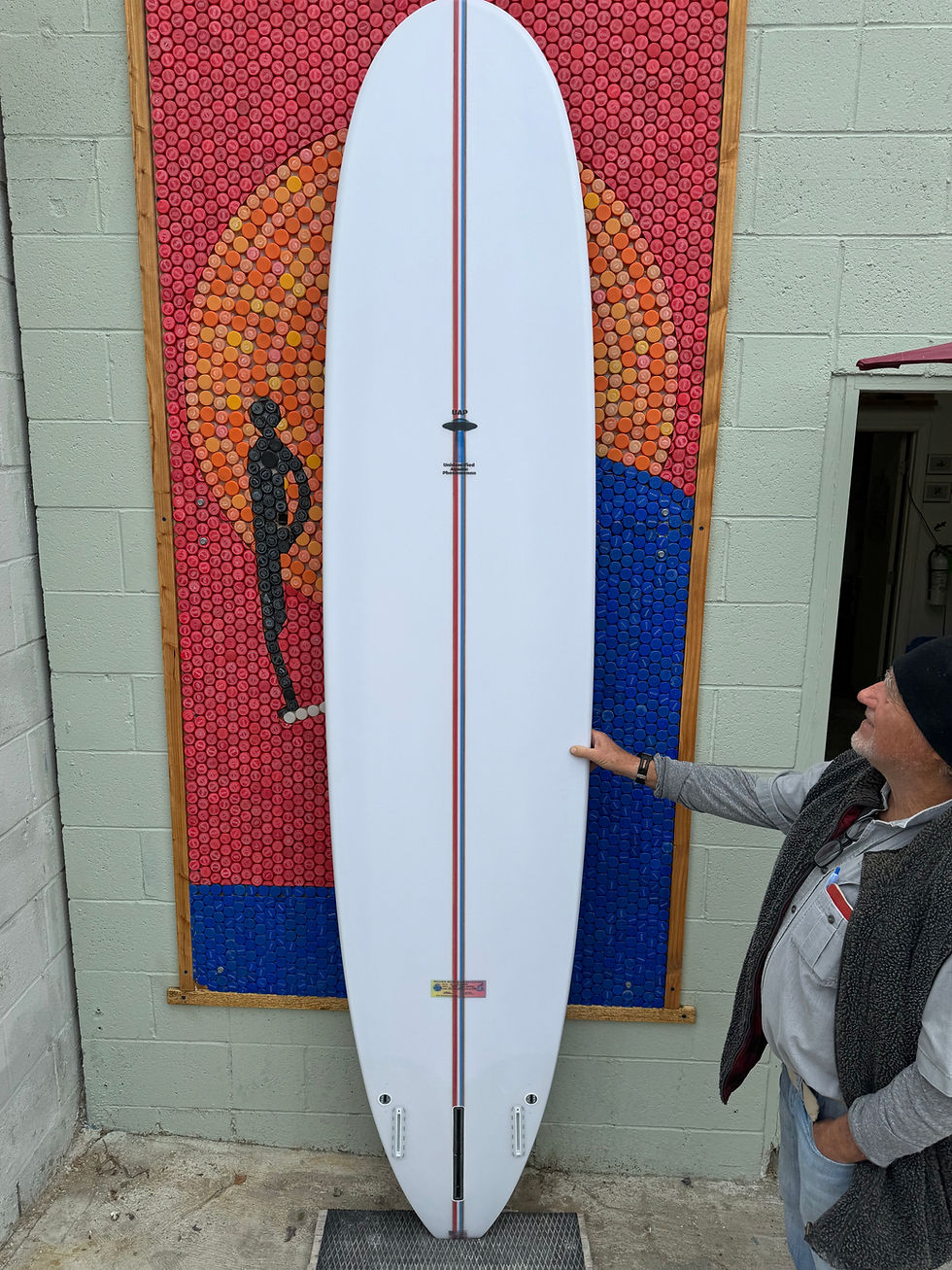 Thumbnail: Man showing a white longboard surfboard