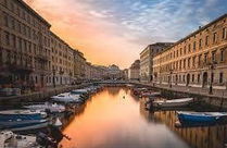 City canal with boats and buildings at sunset