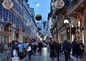 City street with holiday lights, people, and buildings