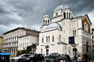 Ornate white cathedral with domes under a cloudy sky