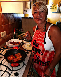 Helena smiling and cooking in her kitchen