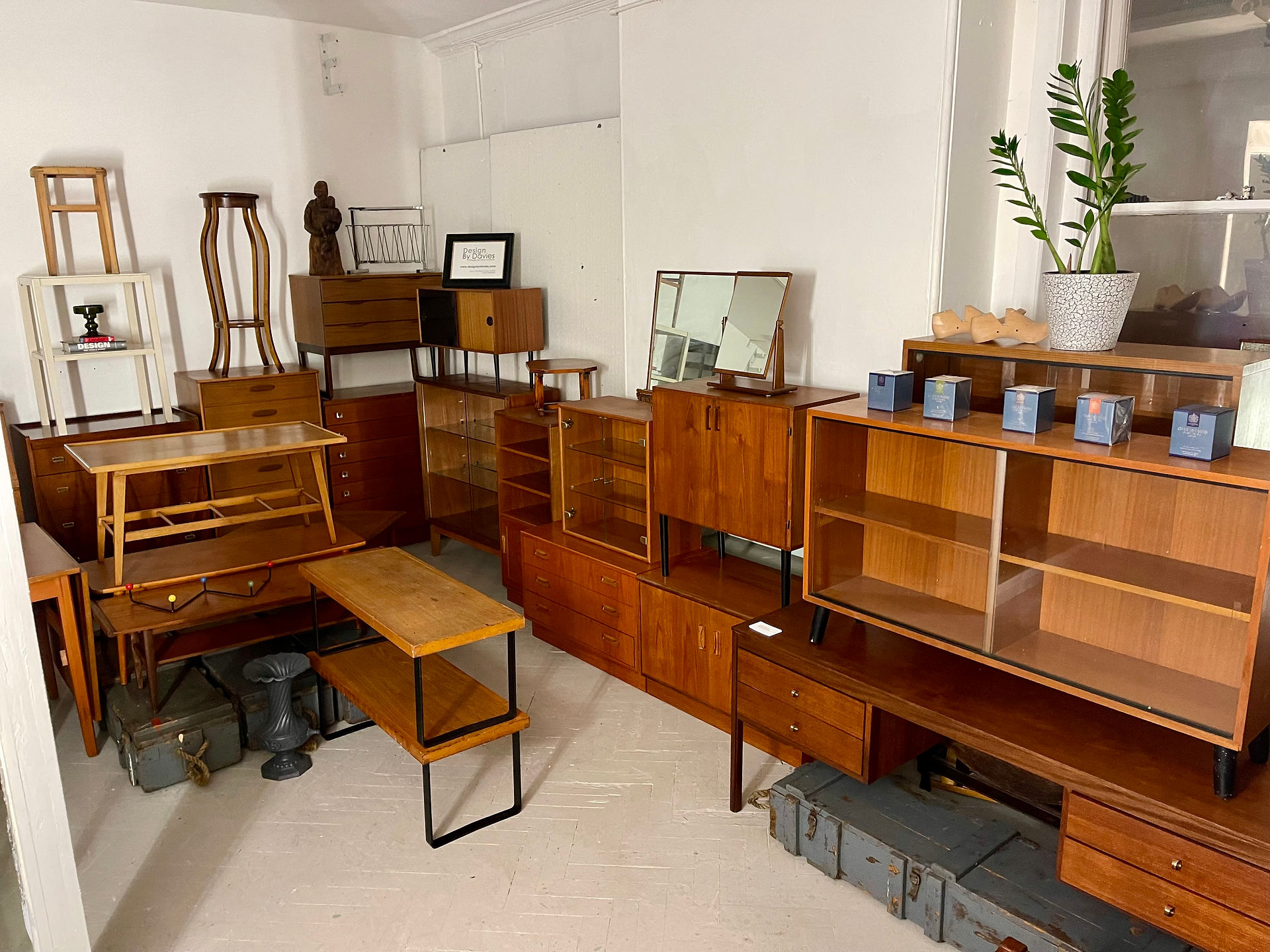 Collection of vintage wooden furniture displayed in a well-lit room for sale
