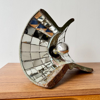 Decorative lamp with mirror tiles, vintage style, resting on wooden table.