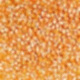 Close-up of orange popcorn kernels scattered, featuring their shiny, smooth texture. The background is completely filled with kernels.