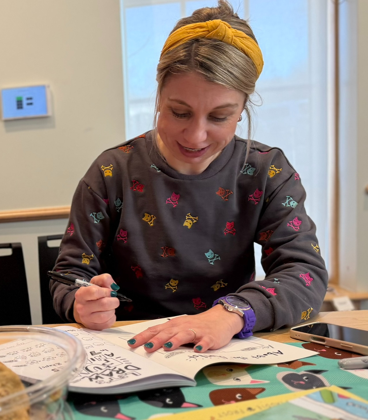 Maddie signing bookplates