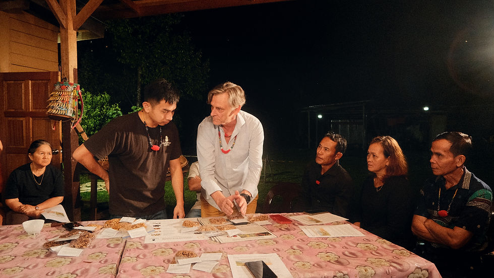 People gather around a table with papers during a conversation on the documentary shoot.