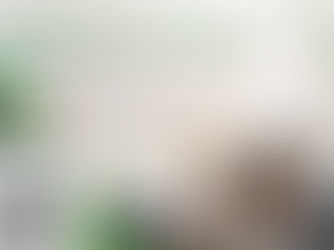 Man lying on a bed, smiling at his phone. Laundry and snacks nearby. Washing machine with detergent in foreground. Text: Be Lazy. Stay Clean.