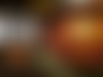 Rustic bowl of three-bean chili topped with sour cream, shredded cheddar, and cilantro, featuring sirloin and kielbasa seasoned with Oak City Spice Blends Bountiful Bahia on a dark wooden table with warm editorial lighting.