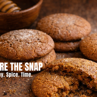 Warm, rustic spice cookies on a wooden surface with one broken open to show a soft interior, styled with a honey dipper and natural light.
