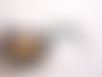 Golden Welsh cakes cooking in a cast iron skillet with one broken open to show a soft, crumbly interior with raisins, styled in soft natural light with a simple linen cloth.