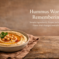 Creamy hummus in a rustic ceramic bowl swirled with olive oil and topped with paprika, chickpeas, and parsley, served with torn pita on a wooden table, with bold editorial text reading “Hummus Worth Remembering.”