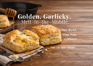 Cheddar yogurt biscuits, golden and flaky with visible herb flecks, cooling on a kitchen counter.