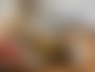 Rustic Easter dinner table with sliced glazed ham, roasted potatoes and spring vegetables, and carrot cake in soft natural light with space for text on the right