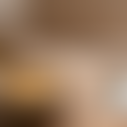 A rustic bowl of creamy white beans with herbs sits on a wooden table beside torn bread and olive oil, lit by soft natural window light with open space for text.