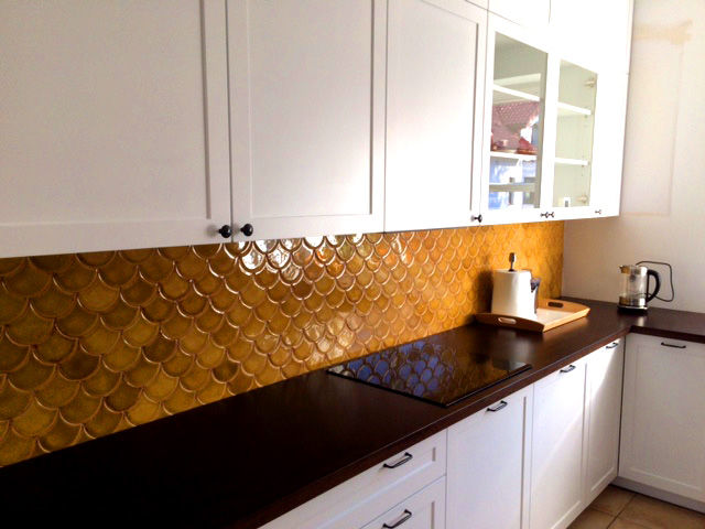 miodowe ręcznie robione kafle ceramiczne w kształcie rybiej łuski nad blatem w kuchni