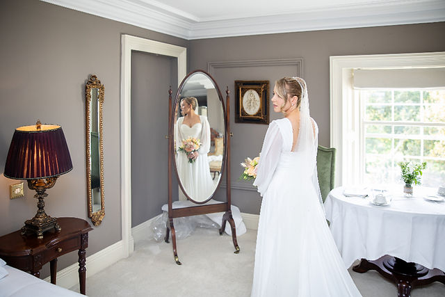 Candid photo of a bride having her hair styled before the ceremony.