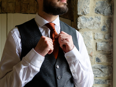 Groomsman laughing while preparing for the big day.