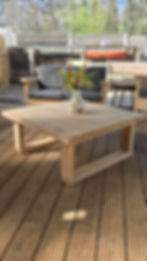 This image shows a simple, Cedar coffee table on what appears to be a deck or patio area with wooden flooring.
