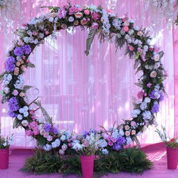 Wedding backdrop made with cascading lavender drapes, fairy lights, and floral hangings for a whimsi