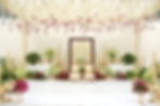 Elegant South Indian wedding mandap with white floral ceiling, gold décor elements, Ganesha backdrop