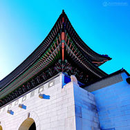 Korean Palace architecture: intricate roofline against a vibrant blue sky