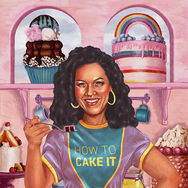 Smiling woman in "How to Cake It" shirt holds cake
