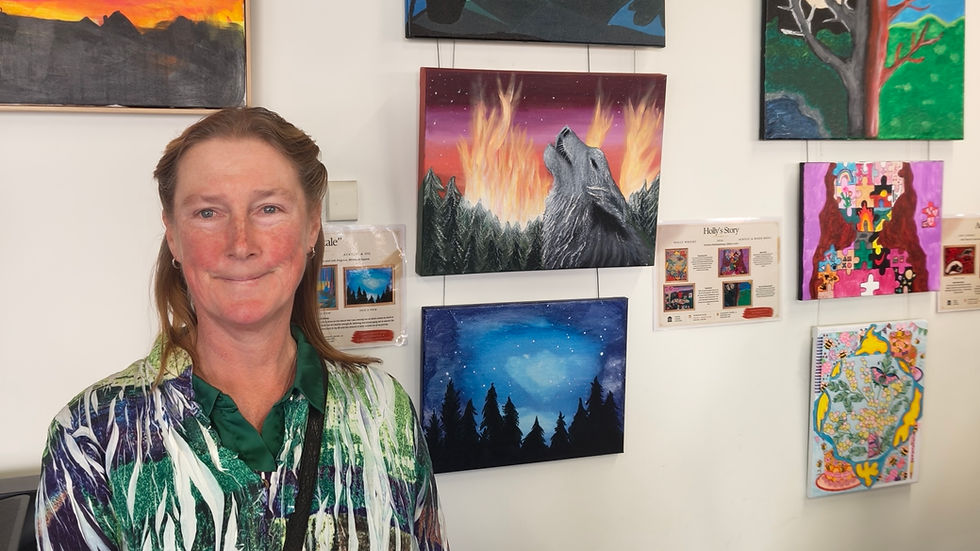 Tara with her paintings at the Warrondi Engage and Link (WEL) Day Program art exhibition. Image: Kirralee Nicolle