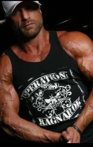 Muscular man in a black tank top with "Operation: Ragnarok" text, flexing arms. Wears a white cap. Dark background enhances focus.