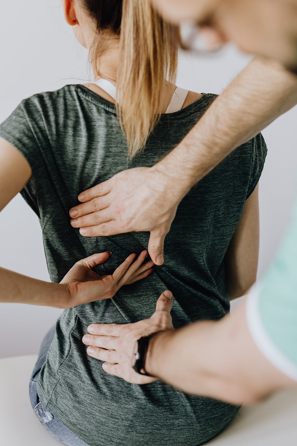 Massage Therapist assessing a woman's back.