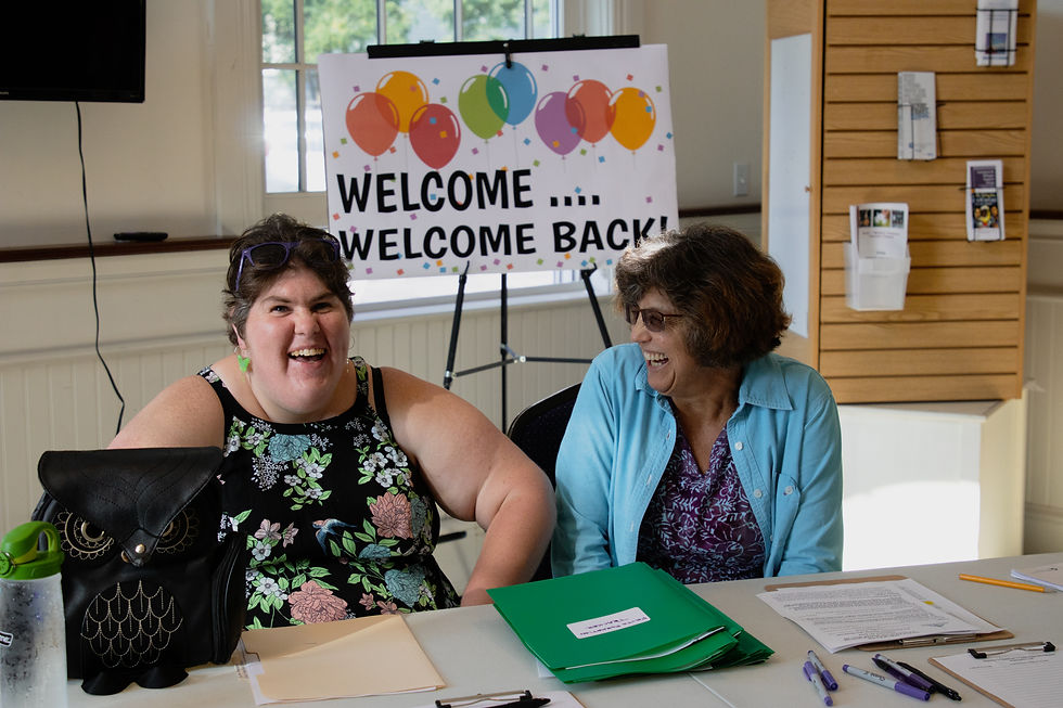 Two women laughing at the greeters desk