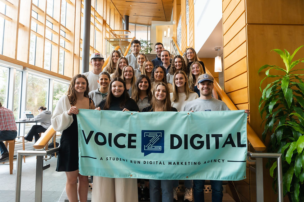 The Voice Z Digital team on a staircase holding a banner reading 'Voice Z Digital, a student-run digital marketing agency.'