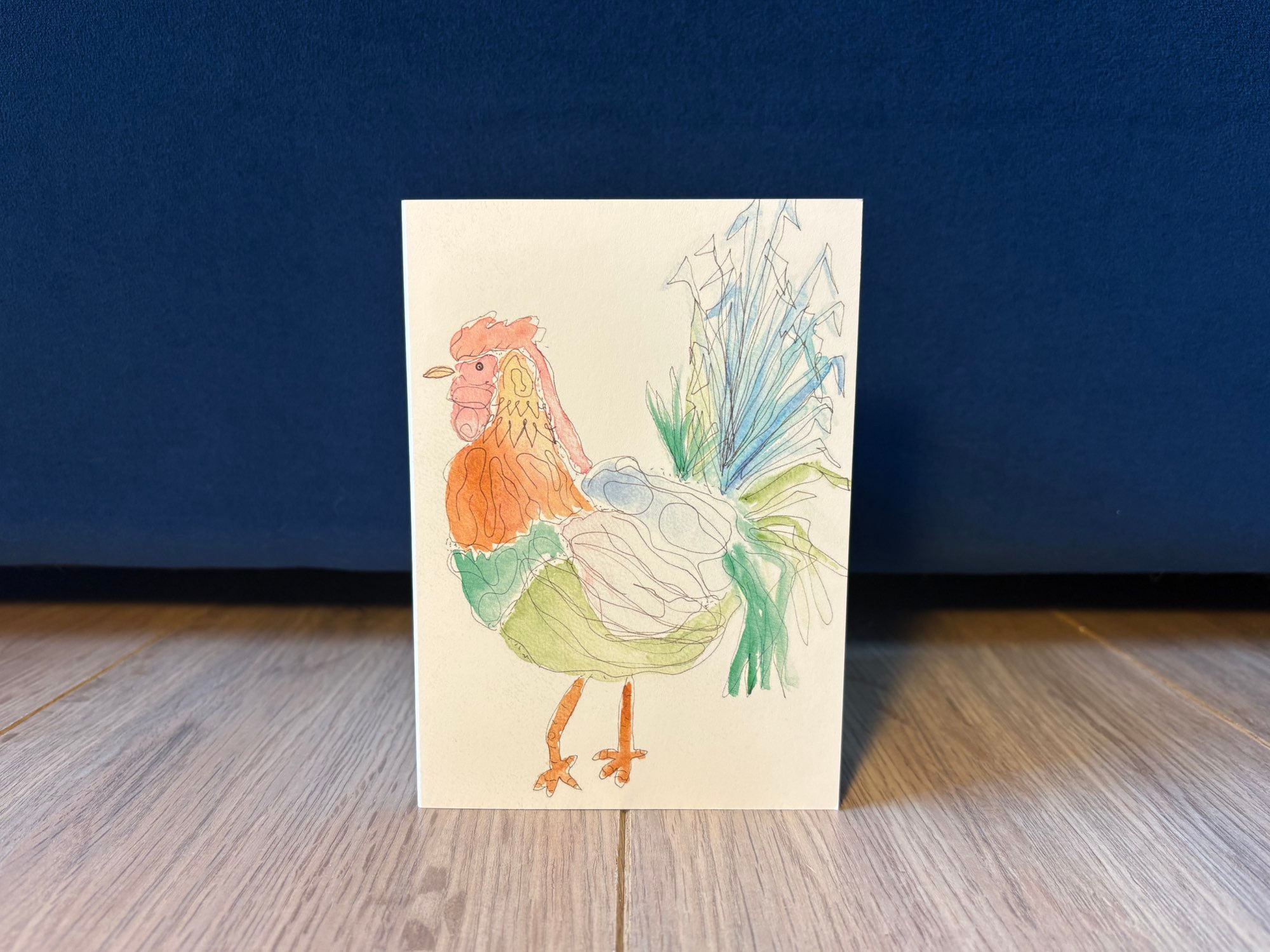 Voorkant kaart met een tekening van een haan in diverse vrolijke kleurjes, aangekleed met vormen en lijnen met fineliner.